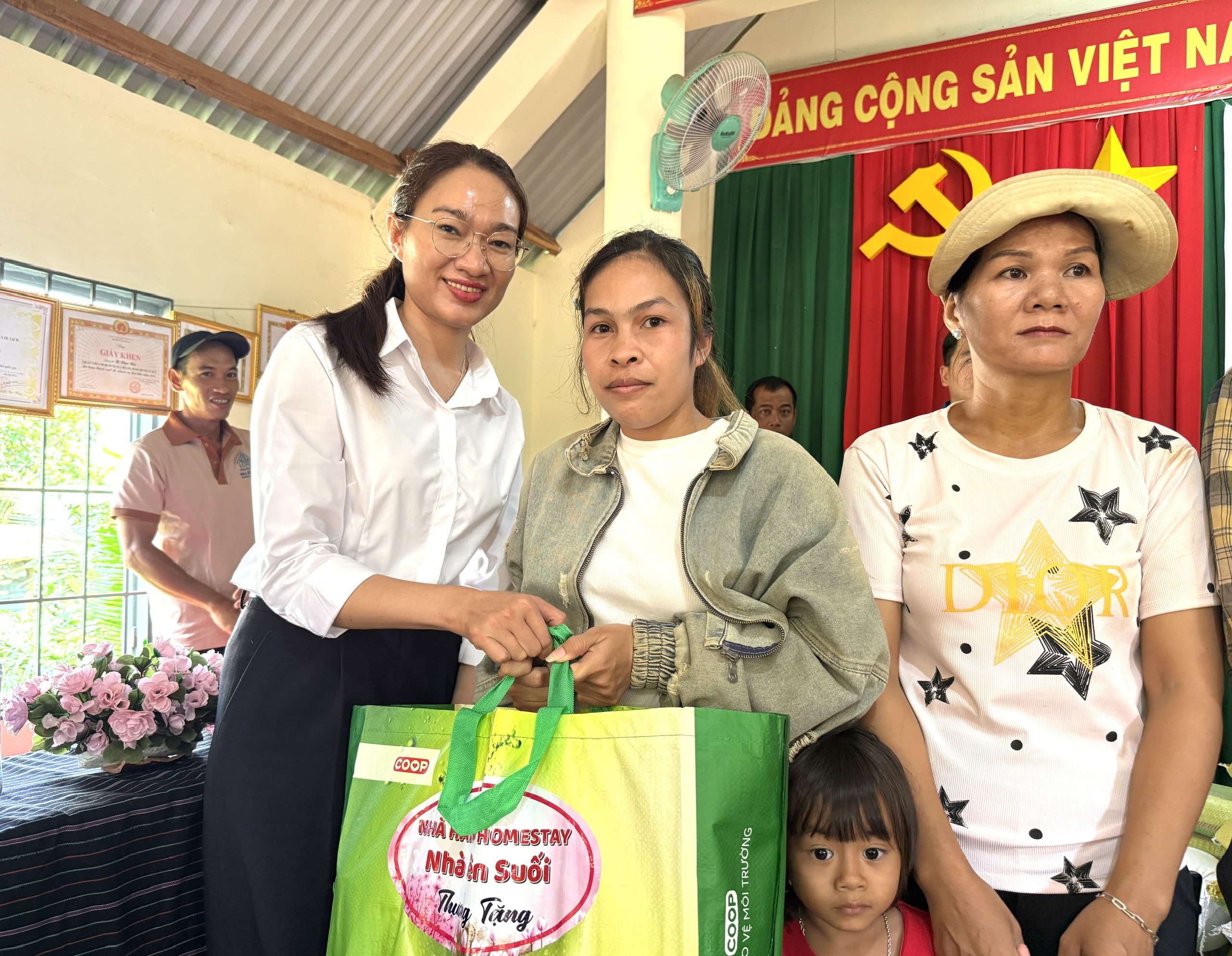 đồng chí Nay H’Lan – Phó Bí thư Thường trực Đảng ủy, Chủ tịch HĐND xã trao quà cho các hộ nghèo, có hoàn cảnh khó khăn